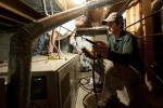 Olaf Sander and Zump Urycki evaluate the heating system of a home in Loveland, Colorado, as part of the Weatherization Assistance Program. | Credit: Dennis Schroeder, NREL.