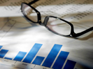 photo of charts on a desk with reading glasses