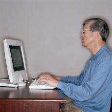 Fotografía de un hombre mayor usando una computadora