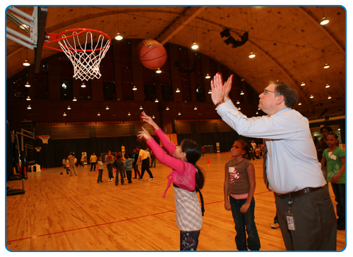 Dr. Tabak teaching a young girl to play basketball