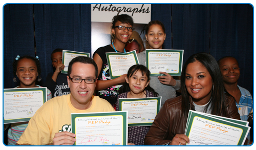 Photo of Jared and Laila Ali with kids and signed  pledges