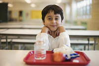 A child sitting in a school cafeteria