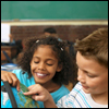 Two children point on a globe