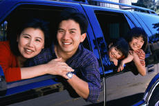 Photograph of a mother, father and young children in an SUV