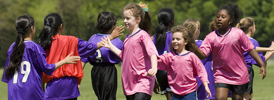 Children demonstrating sportsmanship on a soccer field