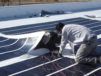 Workers installing solar panels on reservation building