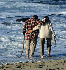 Photograph of a man and woman walking on the beach