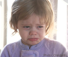 A photograph of a toddler crying