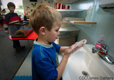 Photograph of a young boy washing his hands