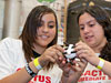 Students wrap an egg with straws and tape for cushioning prior to launching them.