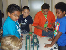 Students check out functions of one of the VEX robots used during the summer robotics workshop.