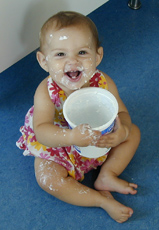 A photograph of a toddler eating yogurt