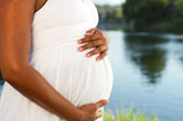 A pregnant woman holds her stomach.