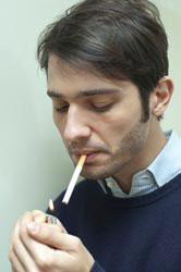 A man lights a cigarette.