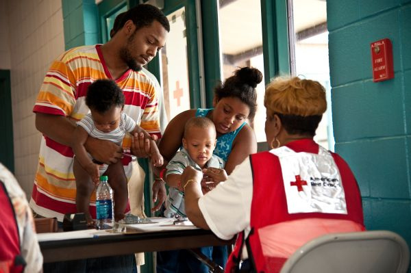 red cross volunteer helps child