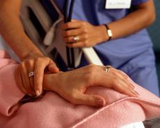 Photograph a female health care professional's hand and a female patient's hand
