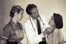 Fotografía de un doctor y una enfermera examinando una paciente