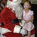 Child sitting on Santa Claus lap at OPM’s Annual Toy Drive