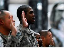 Pfc. Merlan Samuel, second from left, a St. Lucia native assigned to the U.S. Army’s 1st Infantry Division, recites the Oath of Allegiance during the Feb. 21 naturalization ceremony at Camp Victory, Iraq. (Photo courtesy of the U.S. Army)