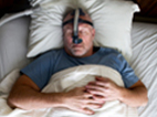 Photo of a man receiving sleep apnea treatment.