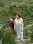 Photo of two women walking on the beach steps.