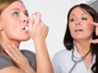 Photo of a woman using asthma treatment.