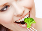 image of Woman eating broccoli 