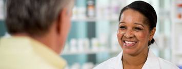 Photo: Pharmacist smiling and talking to customer