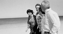 Four people walking on the beach.