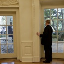 A U.S. Secret Service agent prepares to open the door to the Oval Office for President Barack Obama.