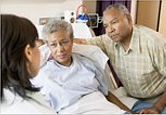 African-American senior couple talking with doctor