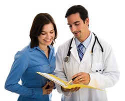 A woman and a doctor reviewing a chart.