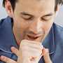 Photo: Man coughing and holding chest