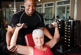 A senior woman exercising with a personal trainer