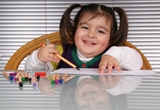 Overweight girl sitting at a table and coloring