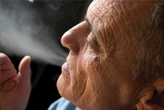 Mature man blowing smoke out of his mouth