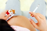 Pregnant woman holding cigarettes