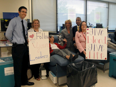 group of people holding signs in the NIH blood bank
