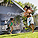 Father playing with children in front lawn sprinkler