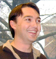 Young man smiling in front of a window