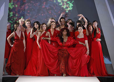 Group of celebrity women of various ethnicities wearing red dresses at the end of a runway