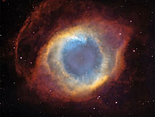 Red and yellow gases surround the blue center of the Helix Nebula