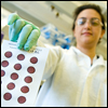 A CDC scientist holds a test strip of blood samples taken for newborn screenings.