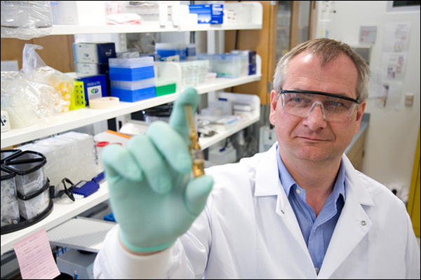 A laboratory researcher holds a vial used to research human hormone measurement.