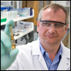 A laboratory researcher holds a vial used to research human hormone measurement.