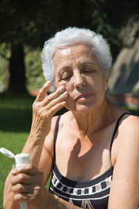 woman applying sunscreen to her face