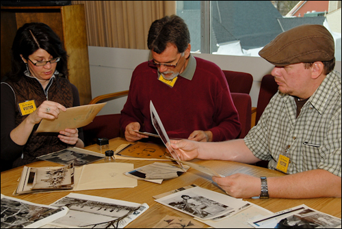            Tom Kaye (center), Carol Abraczinskas, and Brian Ingram examine archival photographs