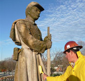 Man cleaning mold off statue