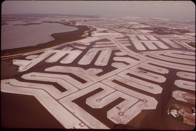 Marco Island Land Development on the Southwest Florida Coast. Many Coastal Developers Dig Channels for Waterfront Property Lots. But Since Hard-To-Get State Permits Are Required to Open the Channels to the Ocean, Small Land Plugs Are Left between the Channel Exits and the Open Water. Buyers, Meanwhile, Are Assured That Such Plugs Are Temporary.