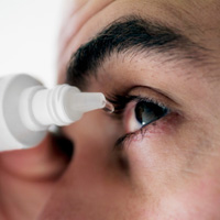 Photo: Man using eyedrops